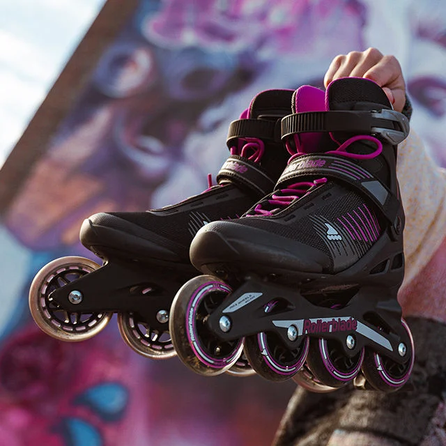 Athlete holding rollerblades.