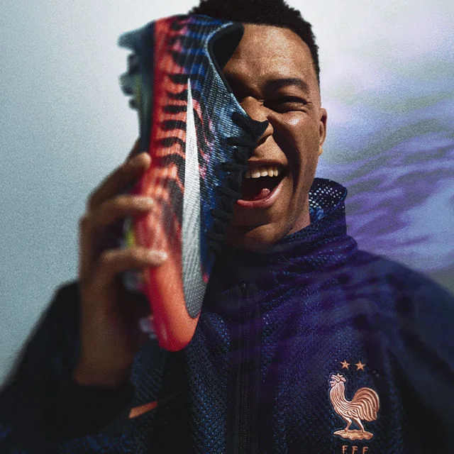 kylian mbappe holding a cleat.