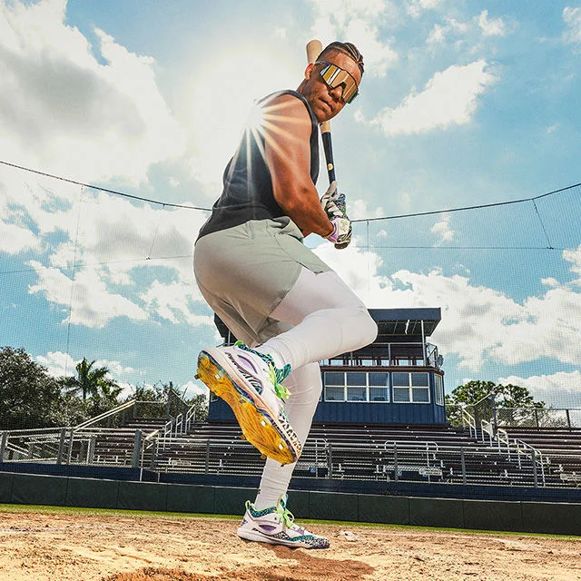 Baseball player showing off cleats.