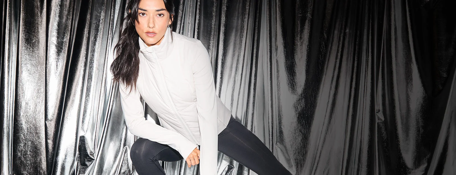 Woman in front of a silver background. 