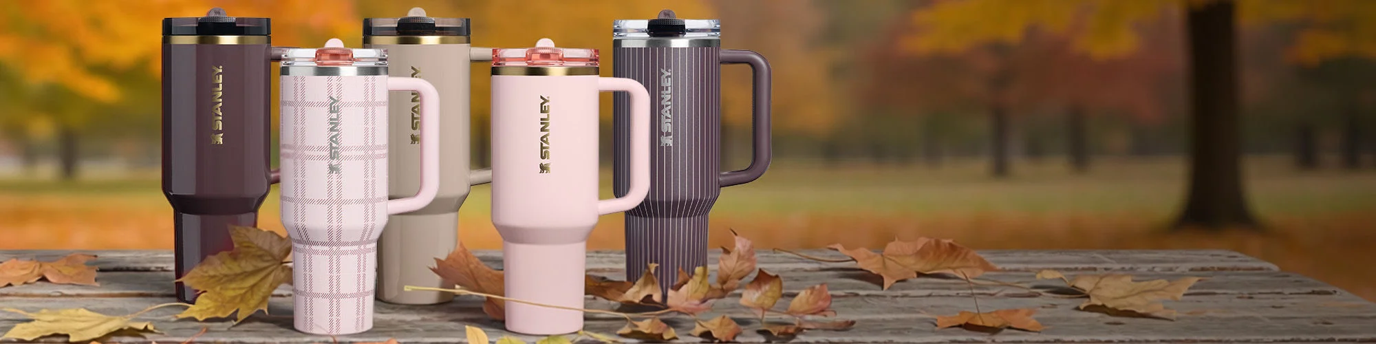 Fall themes Stanley water bottles on a picnic table
