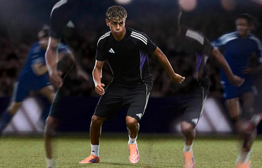 Three pairs of soccer cleats on turf. 