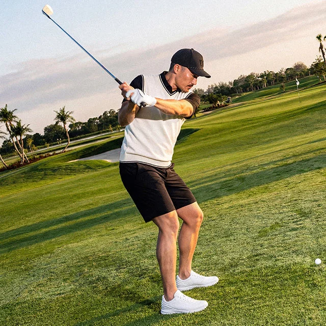 Golfer swinging club.