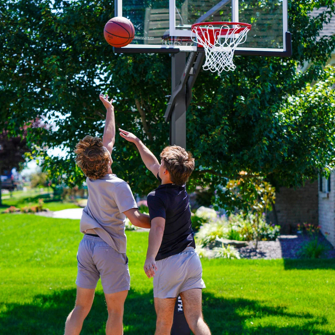 Two athletes outdoor playing basketball.