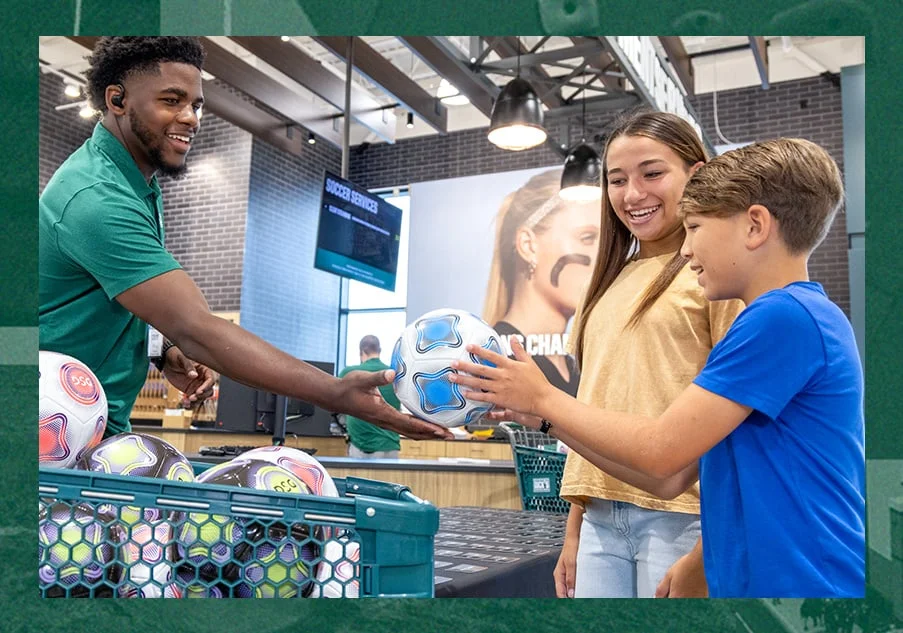 Child getting a soccer ball from DICK'S teammate. 