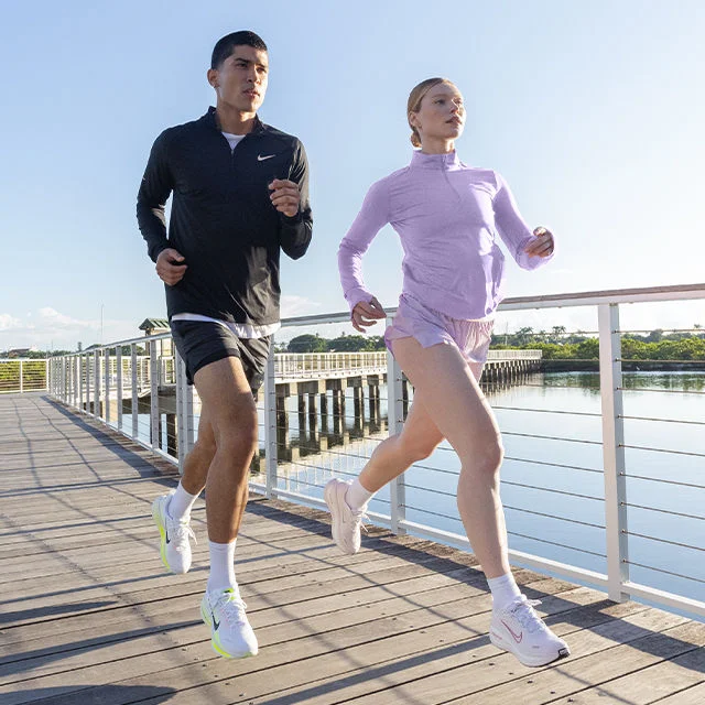 Two athletes outdoors running.