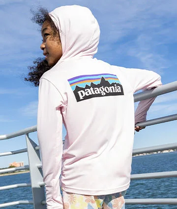 A young girl outside in a longsleeve top.