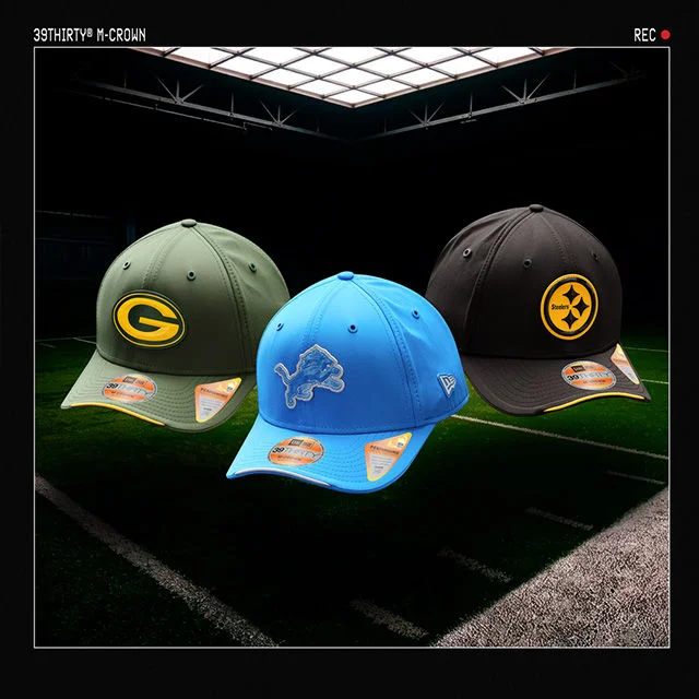 NFL hats on football background.