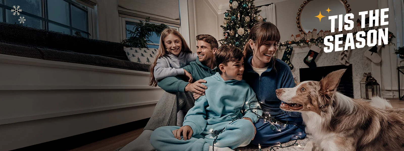 Family sitting indoors with dog.