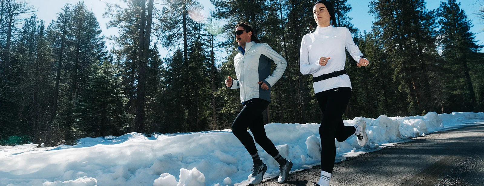 Two people running outside in the snow. 