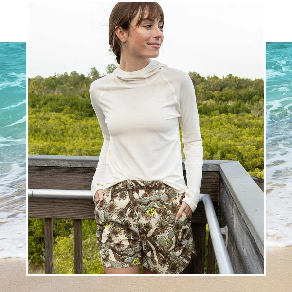 A woman outside in a long sleeve top.