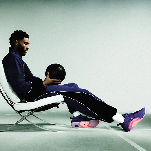 Jason Tatum holidng basketball, wearing footwear and apparel.