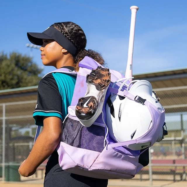 Softball player with lilac colored backpack.