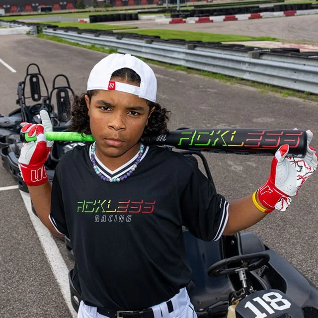 Youth with baseball bat on a go-kart track.