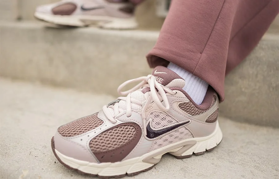 Close up of kid wearing Nike shoe outside on steps. 