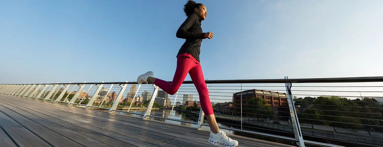 Woman running outside on a bridge. 
