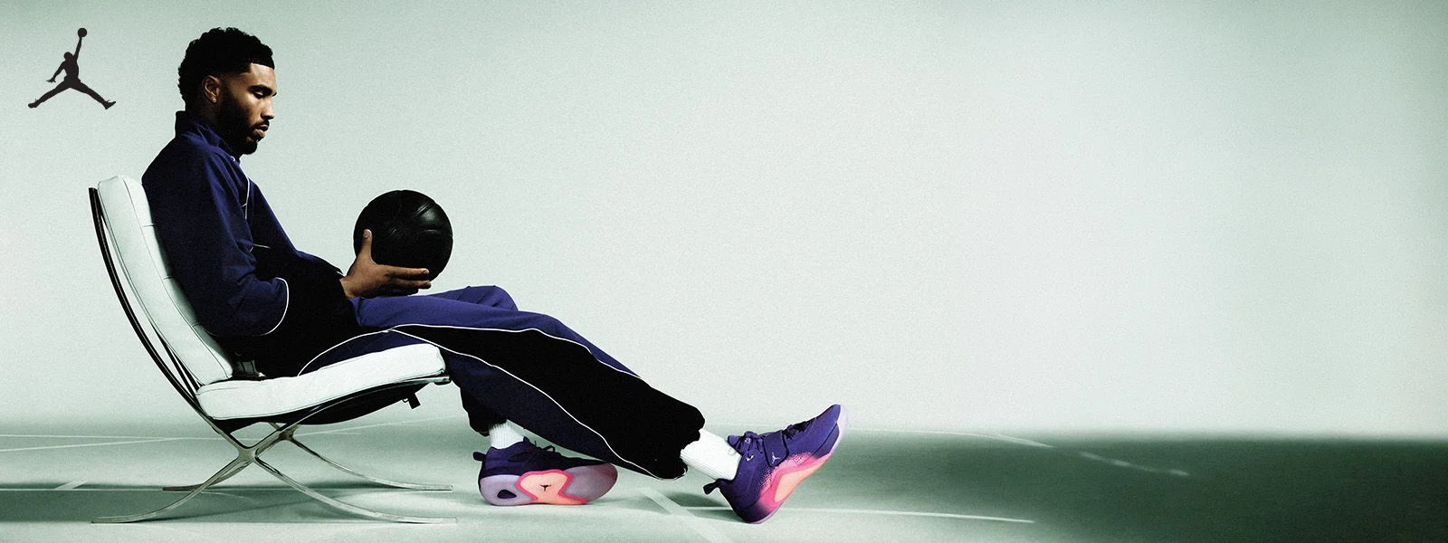 Jason Tatum holidng basketball, wearing footwear and apparel.