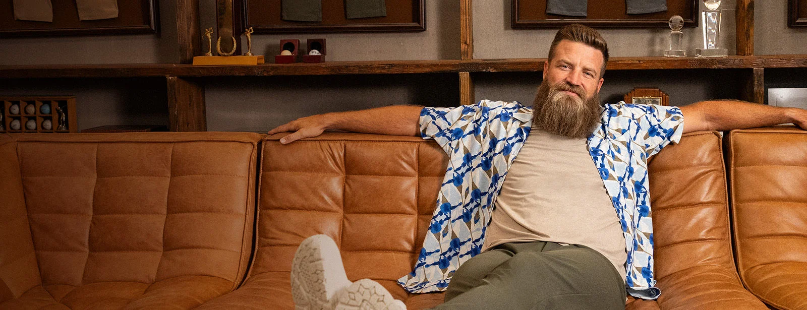 A man sitting on a couch wearing VRST apparel