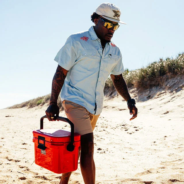 Athlete on beach carrying YETI product.