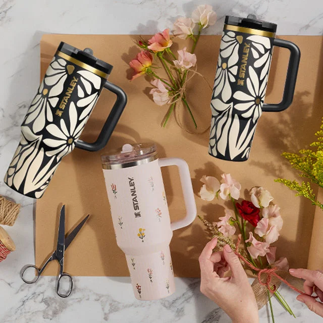 Stanley 1913 drinkware on craft paper surrounded by flowers.