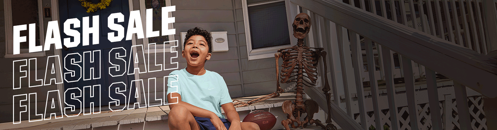 A boy sitting next to a halloween decoration
