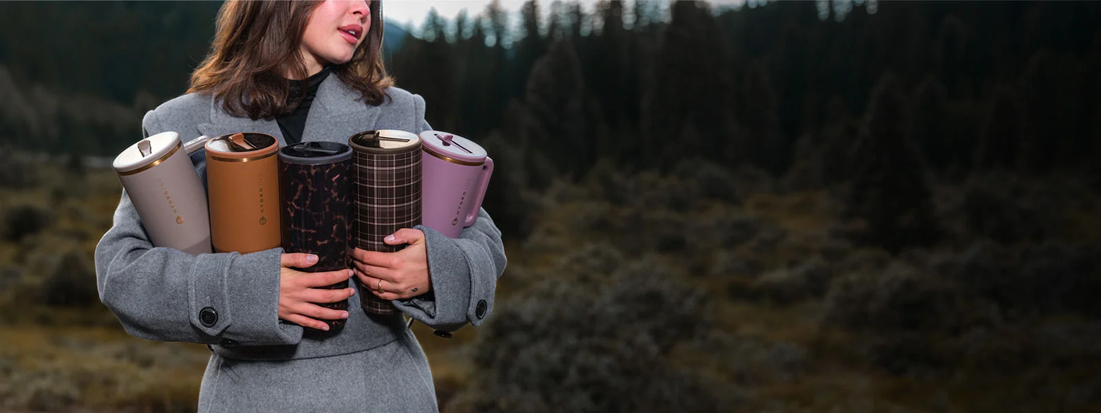A woman holding a collection of Hydrojug water bottles