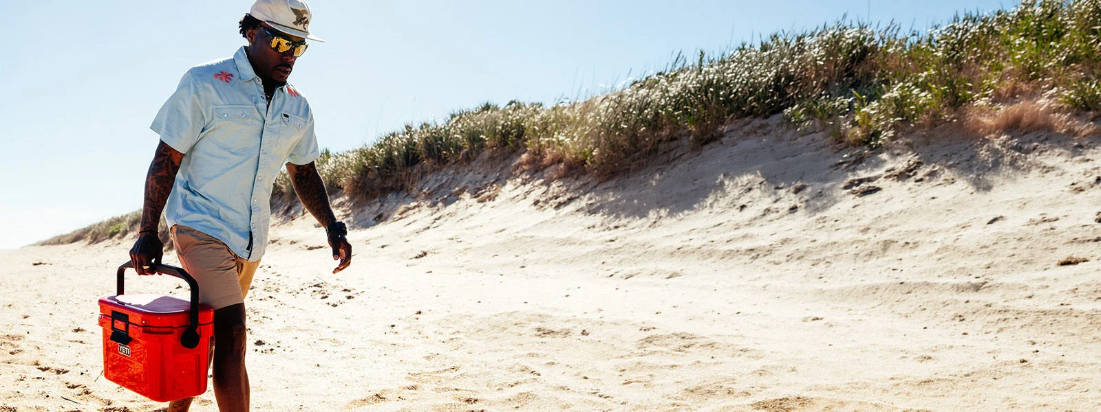 Athlete on beach with yeti product.