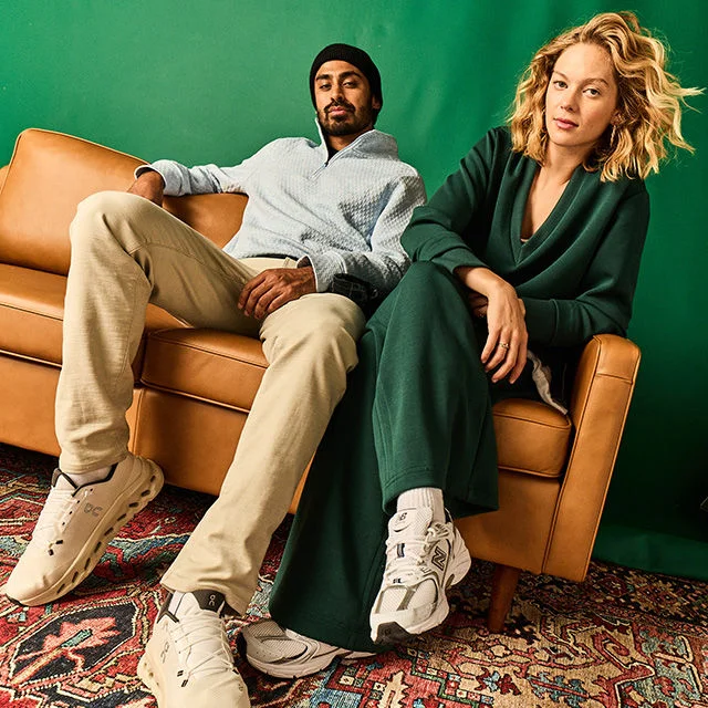 Man and woman on a couch wearing Calia and VRST fleece. 