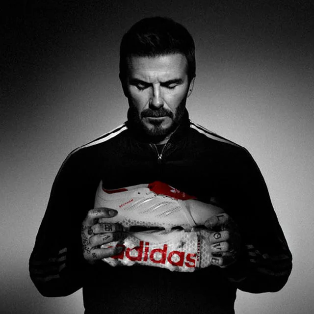 David Beckham holding a soccer cleat