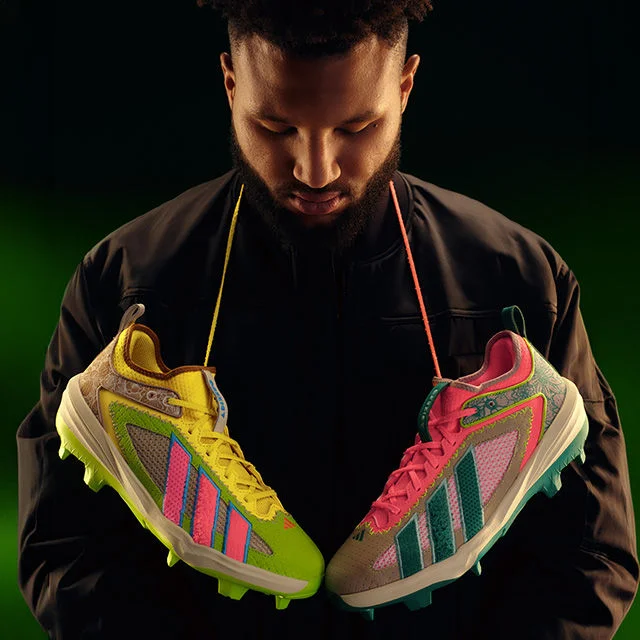 Baseball player showing off cleats.