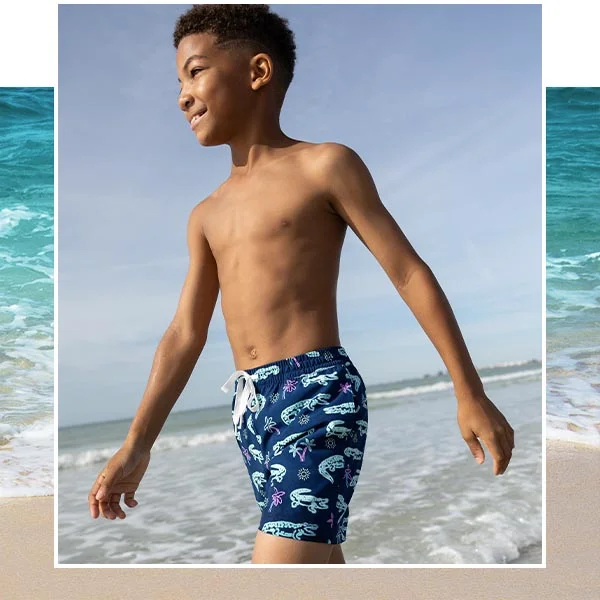 A young boy in swimwear at the beach.