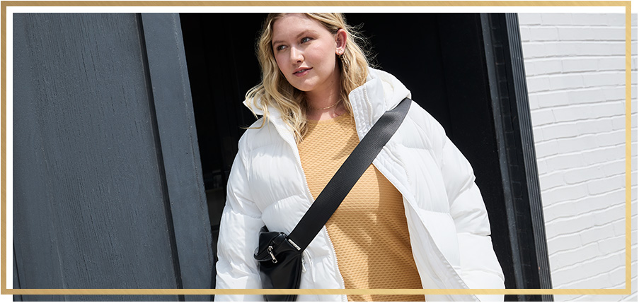 Woman outside wearing a jacket and a cross body bag. 