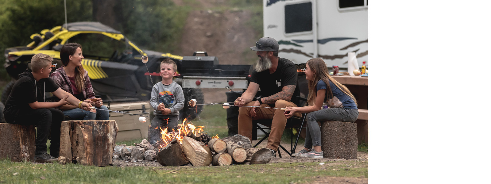 A family roasting marshmallows over a camp fire.