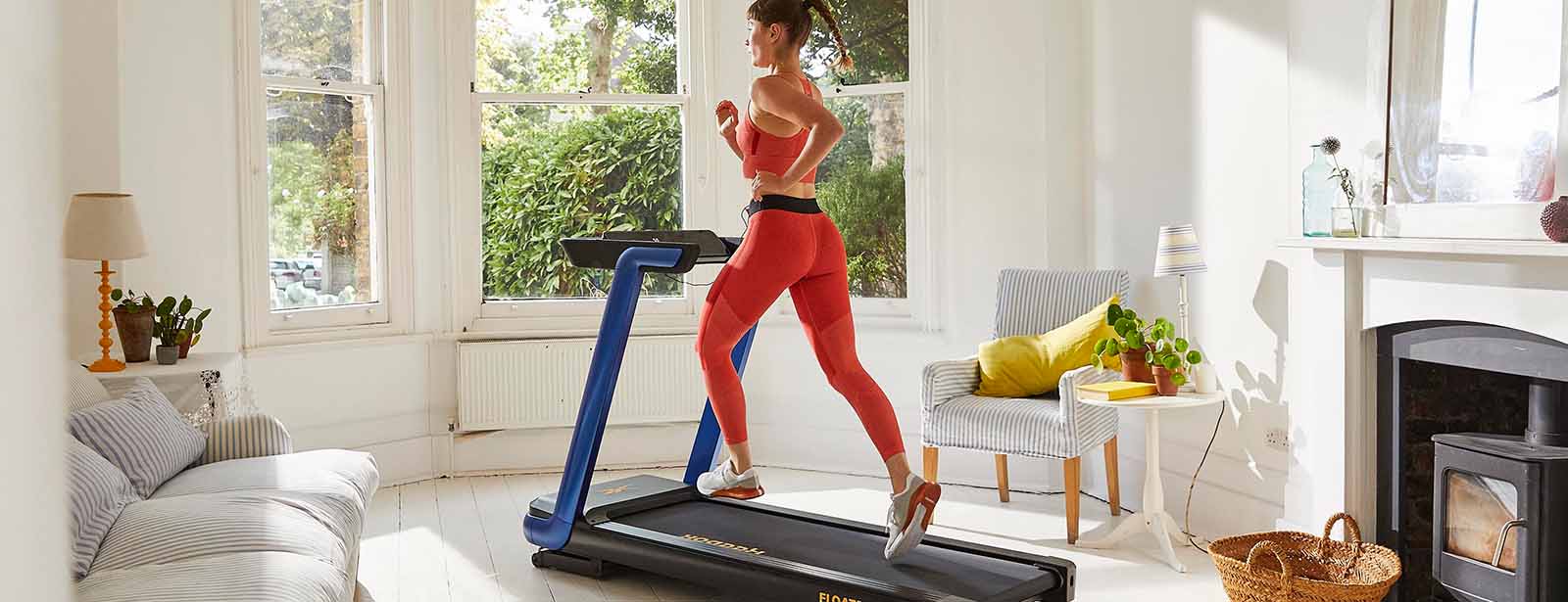 Woman riding Peloton in home gym.