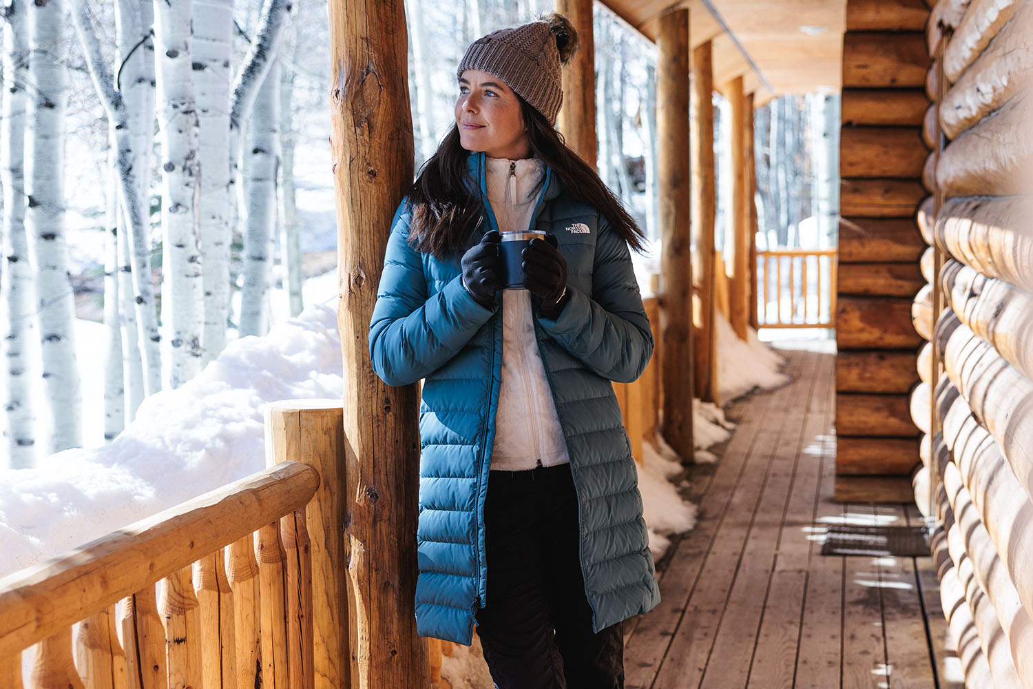 person wearing jacket and beanie with coffee outside