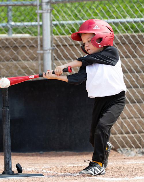 young boy playing teeball