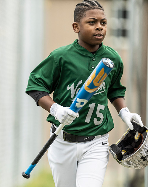 boy running with baseball bat and helmet