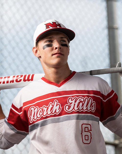 teenage boy in baseball uniform with bat
