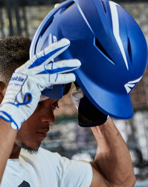 man putting on baseball batting helmet