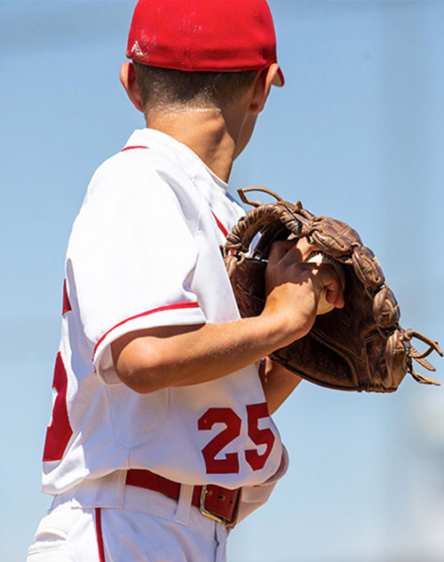 Baseball holding a baseball in his glove