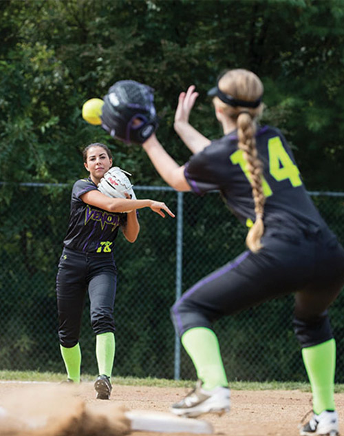 Softball players throwing a ball