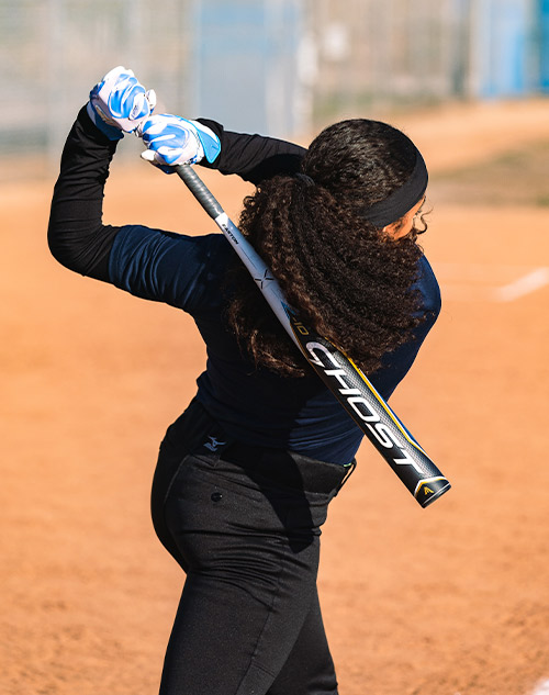 Softball player swinging a bat