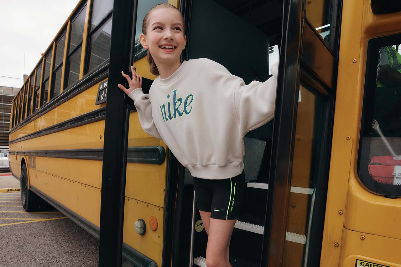 girl hanging out of school bus smiling