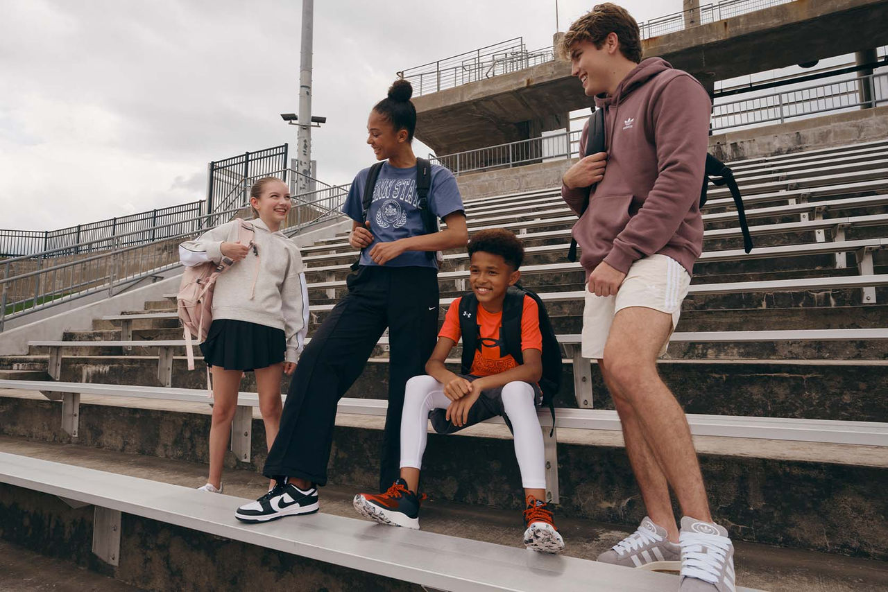teens with backpacks on bleachers
