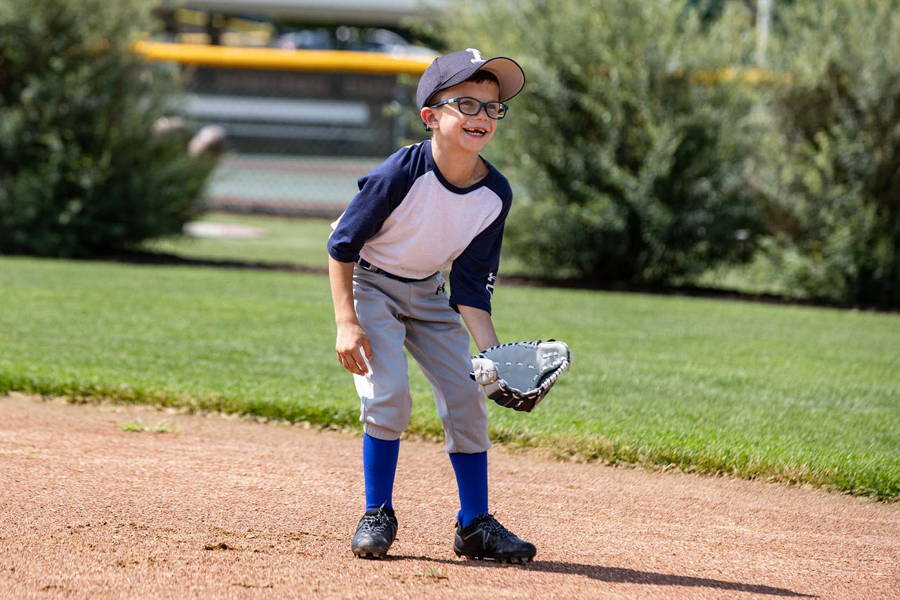 kid playing tee ball on field