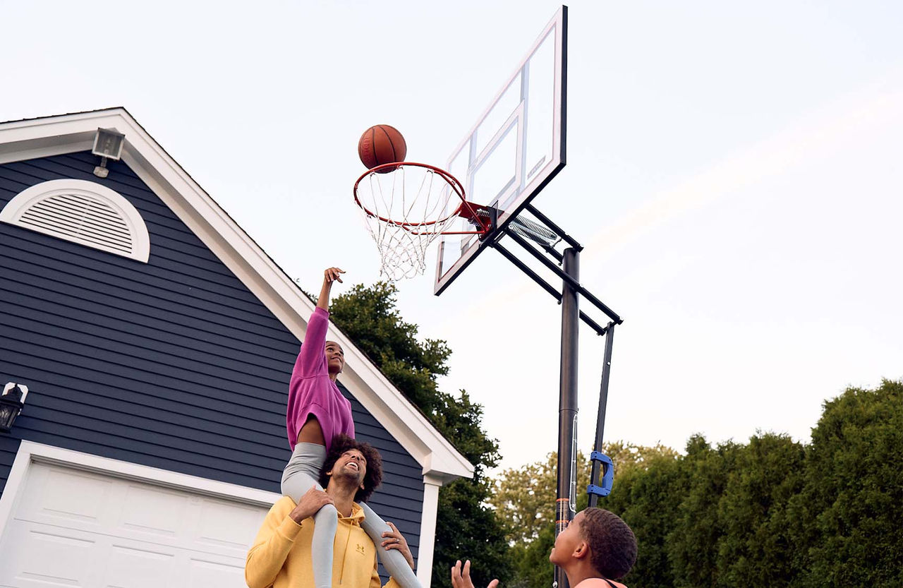 family playing basketball outside