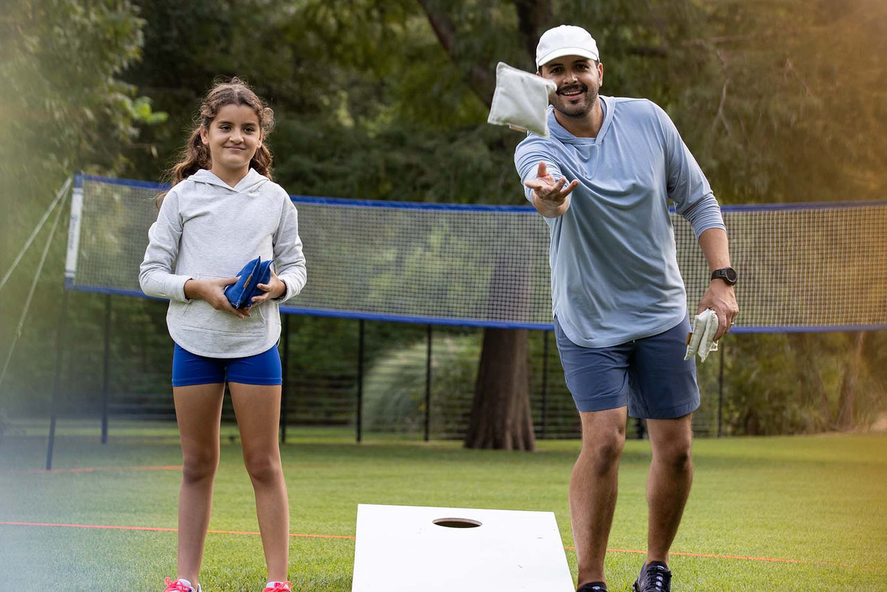 father and daughter playing cornhole