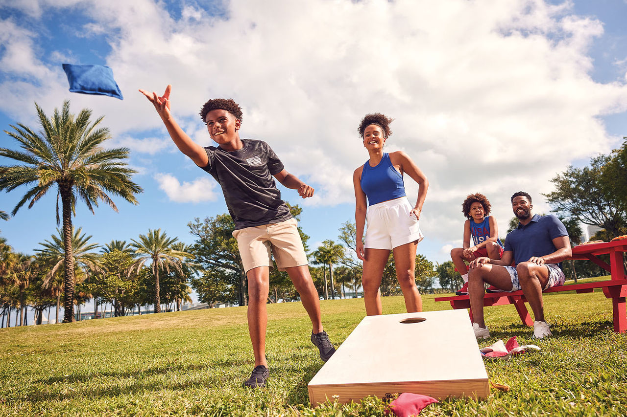 Picture of a family playing a bocce ball in the yard.