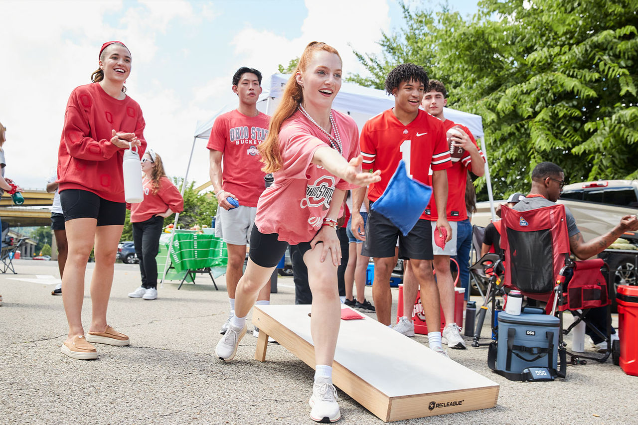 people playing cornhole in parking lot