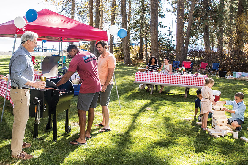 People outside enjoying a back yard cook out.
